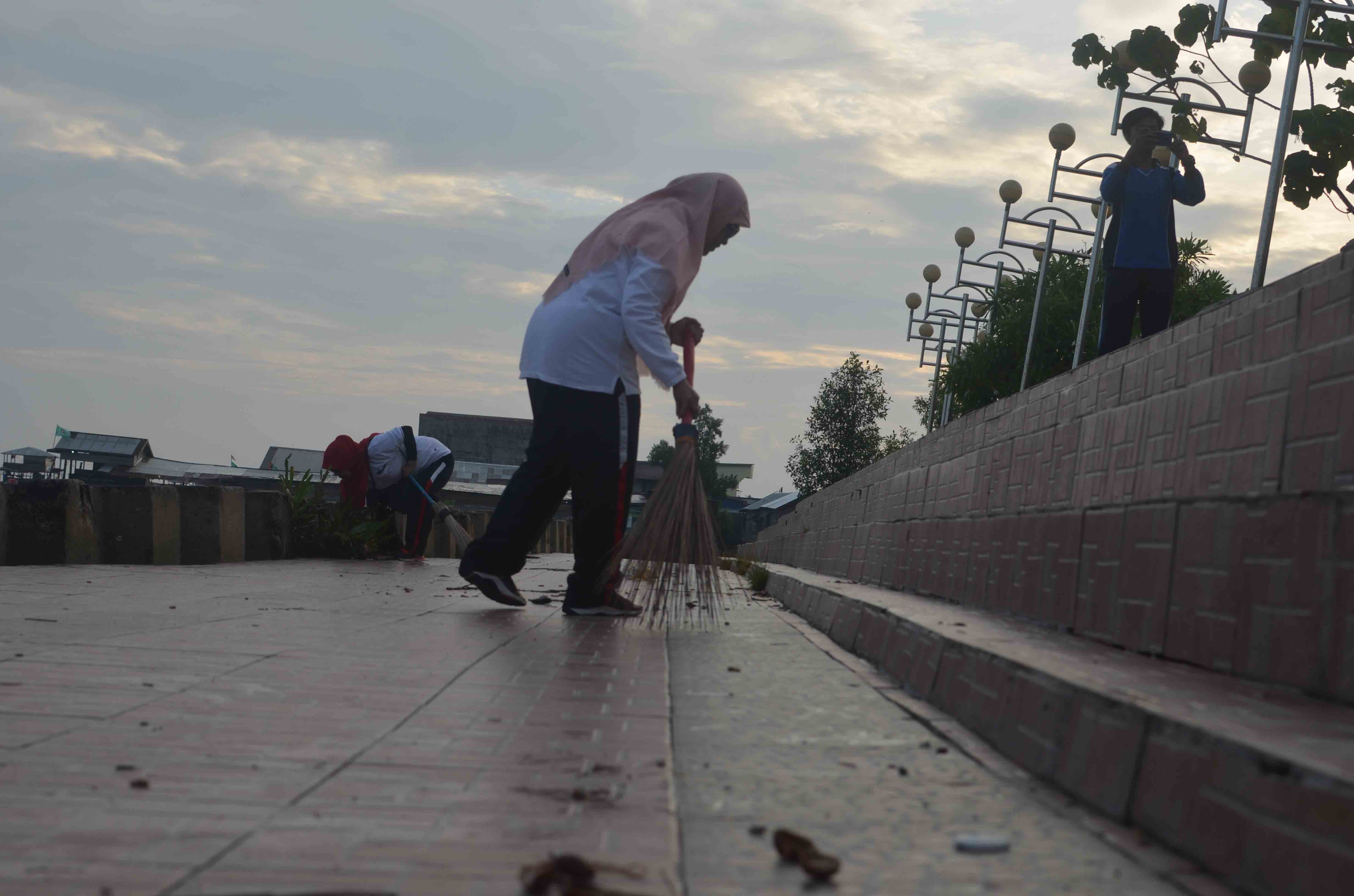Kepala KPPN Kuala Tungkal, Frida Zuliaty, bersama tim sedang menyapu sampah yang berserakan di Ancol Beach, Kuala Tungkal (15/2)